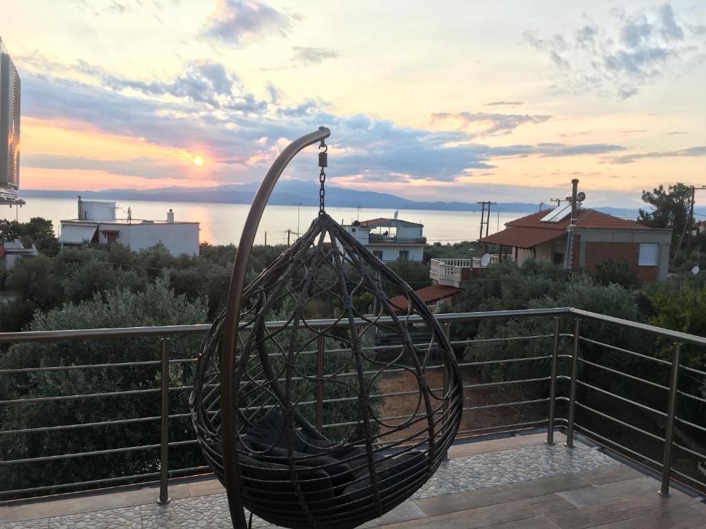 a metal sculpture on a balcony with a sunset in the background at Happy Family in Skala Kallirakhis