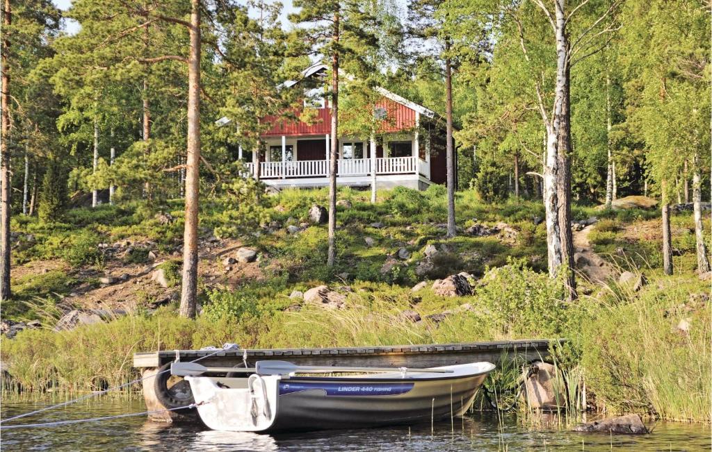 a boat docked in the water in front of a house at 4 Bedroom Gorgeous Home In Frseke in Fröseke