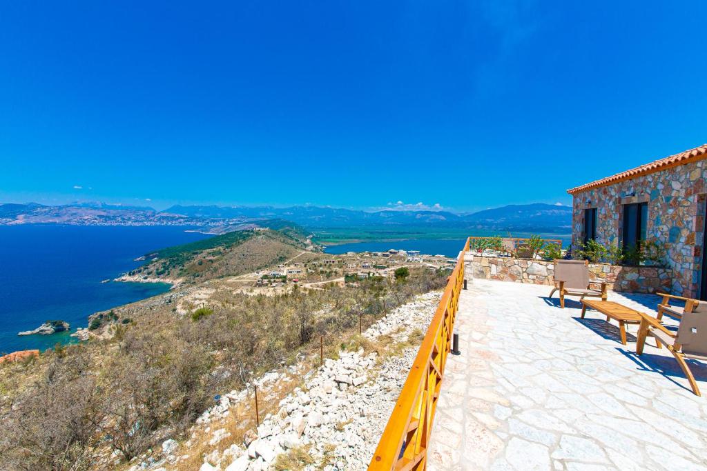 a balcony with chairs and a view of the water at Santa Oliva Suites in Ksamil