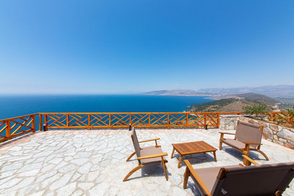 a patio with a table and two chairs and the ocean at Santa Oliva Suites in Ksamil