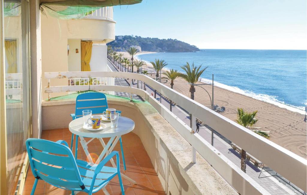 リョレート・デ・マルにある3 Bedroom Beautiful Apartment In Lloret De Marのビーチを見渡すバルコニー(テーブル、椅子付)