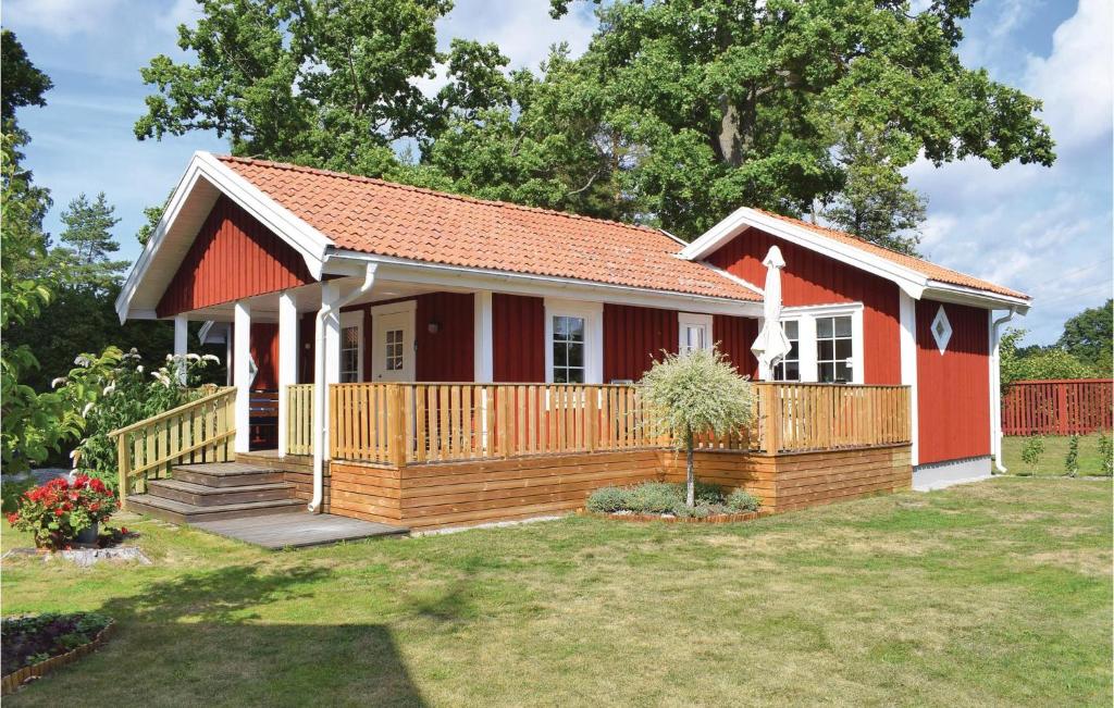 Löttorp的住宿－Awesome Home In Lttorp With Kitchen，一座红色和白色的小房子,设有甲板