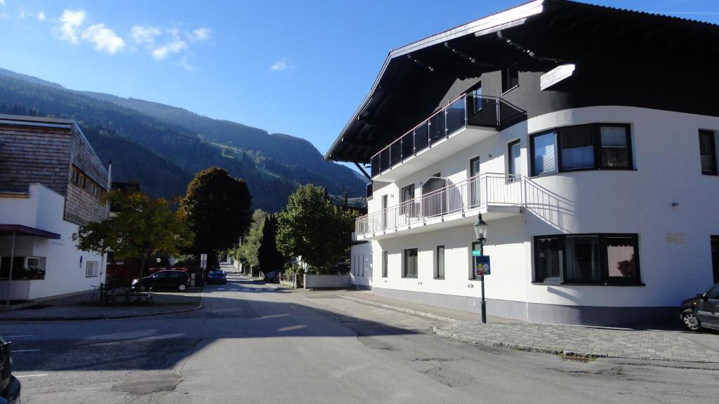a large white building on a street next to a mountain at Haus Schraberger in Schladming