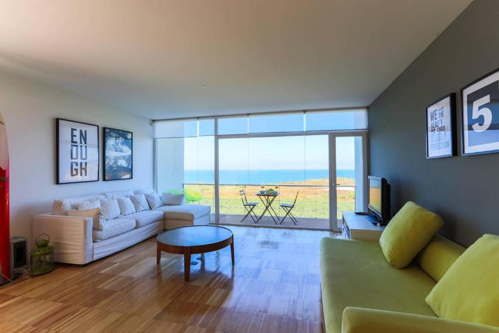 a living room with a couch and a table at Santa Cruz Ocean View Villa in Bombardeira