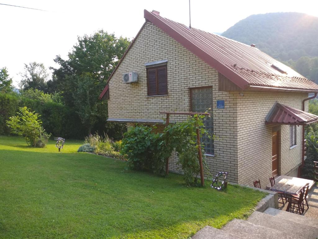 una pequeña casa con un patio con un banco en Holiday Home Zbilje, en Visoko