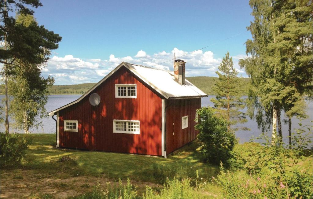 a red barn on the side of a lake at Amazing Home In Rottneros With Kitchen in Bråsstorp