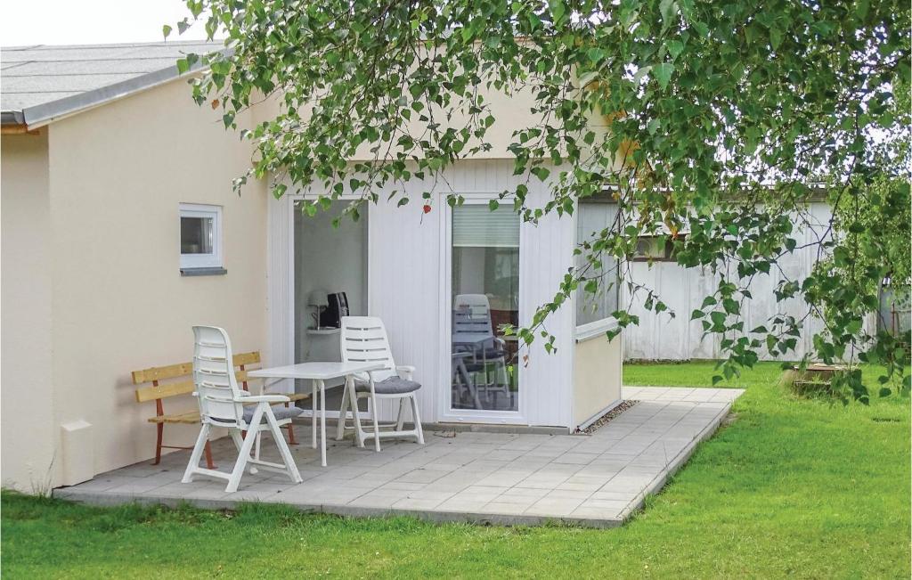 eine Terrasse mit Stühlen und einem Tisch vor einem Haus in der Unterkunft Lovely Home In Insel Poel With Kitchen in Insel Poel