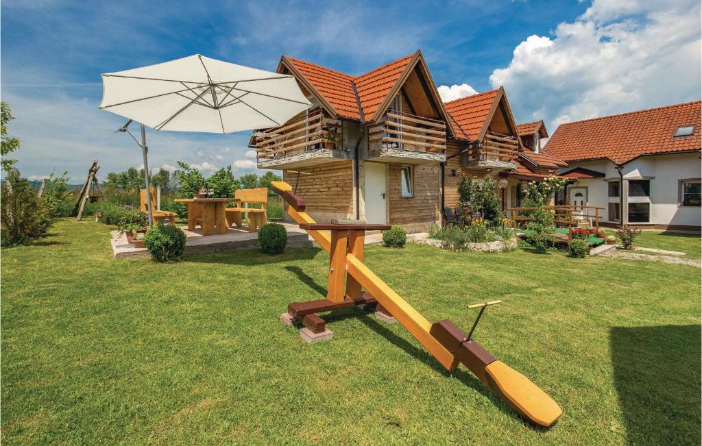 a table and an umbrella in the yard of a house at 2 Bedroom Cozy Home In Licko Lesce in Ličko Lešće