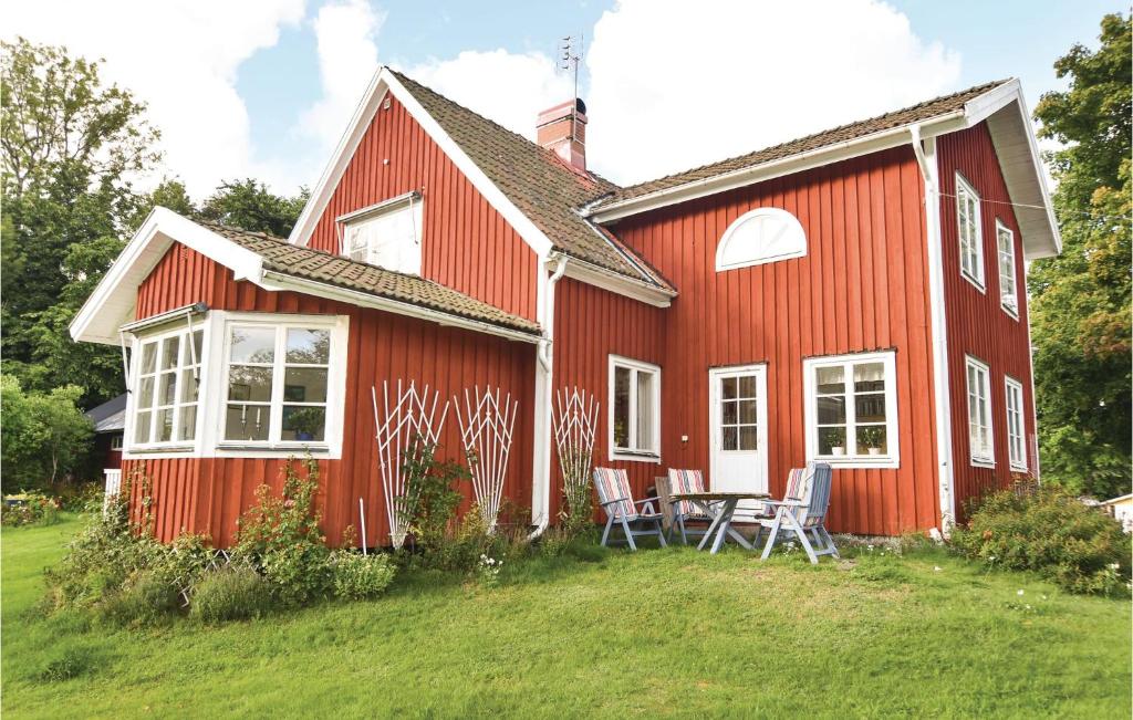 uma casa vermelha com uma mesa e cadeiras em frente em 4 Bedroom Stunning Home In Frgelanda em Färgelanda