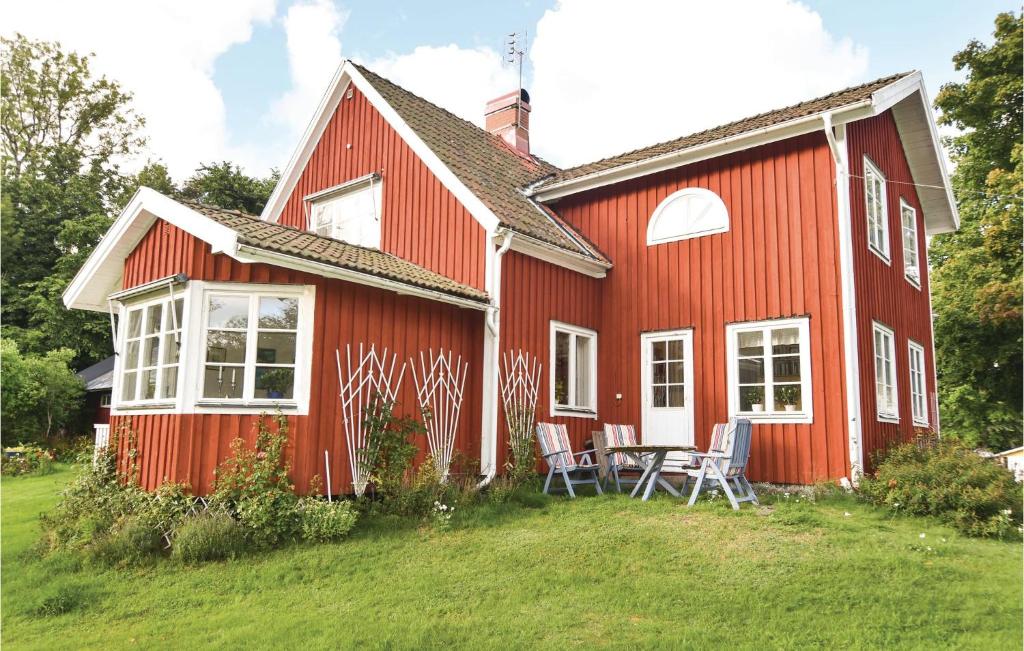 a red house with a table and chairs in front of it at 4 Bedroom Stunning Home In Färgelanda in Färgelanda