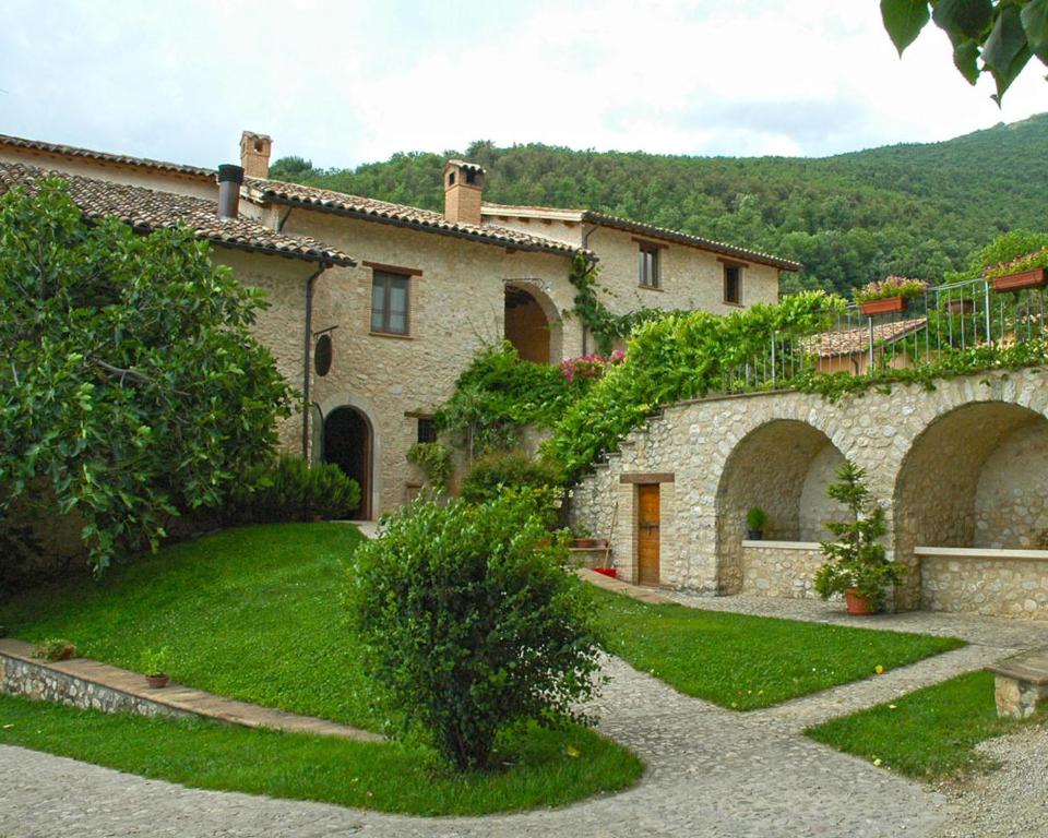 ein großes Steinhaus mit Efeu darauf in der Unterkunft Agriturismo Il Casale Degli Amici in Norcia