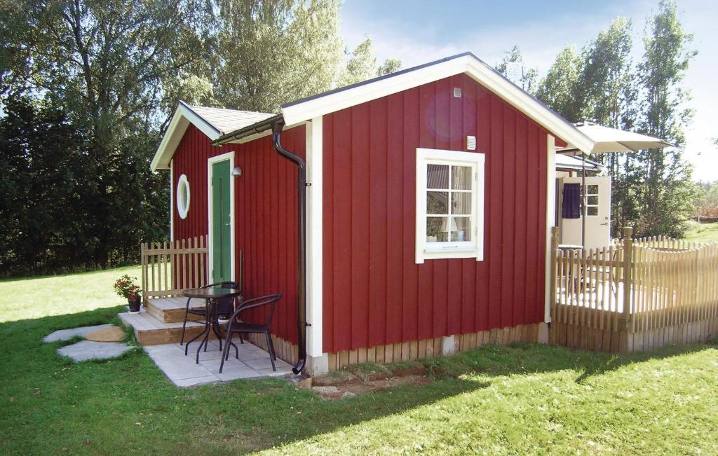 um barracão vermelho com uma mesa num quintal em Nice Home In Sjtofta With Kitchen em Sjötofta