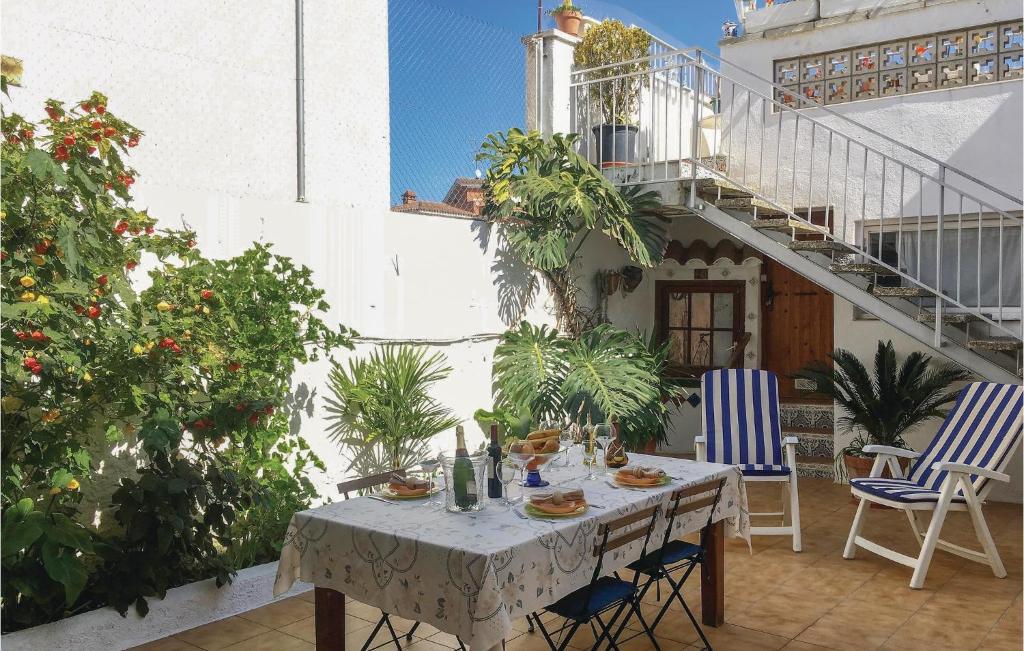 ピネダ・デ・マールにあるAwesome Apartment In Pineda De Mar With 3 Bedrooms And Wifiの植物のあるパティオ(テーブル、椅子付)