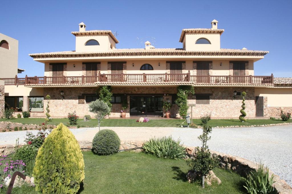 uma casa grande com um grande quintal em frente em Hotel Rural Los Nogales em Pozo Alcón