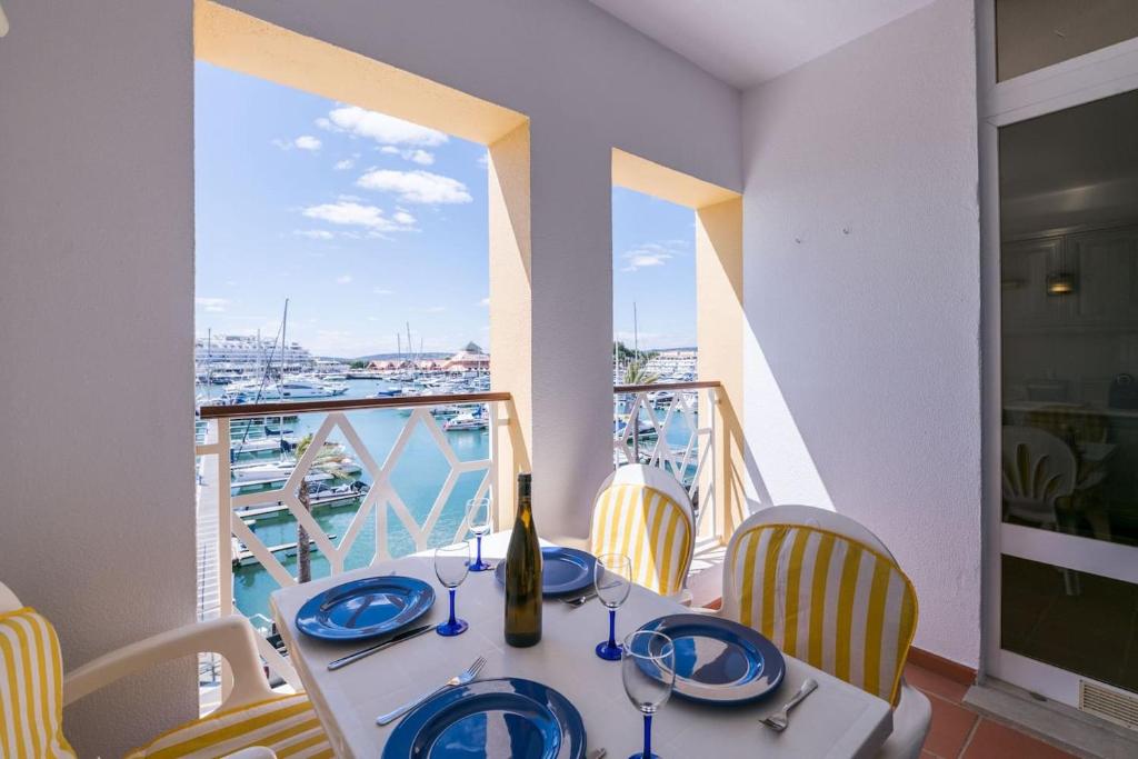 uma mesa com uma garrafa de vinho e cadeiras numa varanda em LovelyStay - Two Bedroom Duplex at Vilamoura Marina em Vilamoura