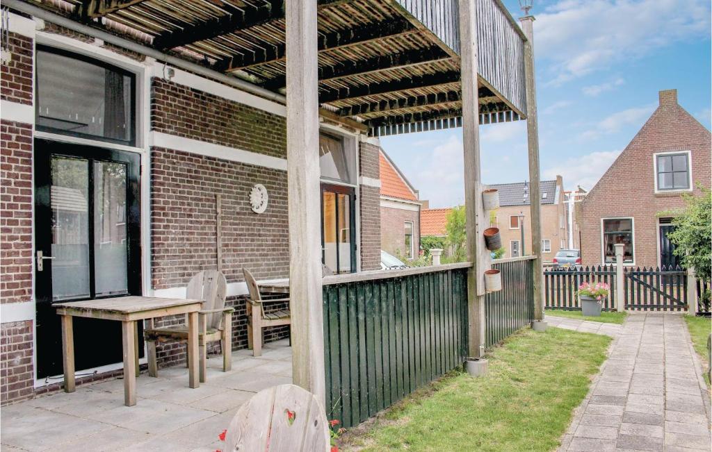a patio with a wooden table and a fence at Appartement 1 - De Eekhof in Hindeloopen