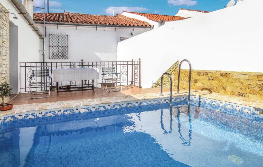 Villaviciosa de CórdobaにあるNice Home In Villaviciosa De Cordob With 4 Bedrooms, Wifi And Outdoor Swimming Poolのテーブルと椅子付きのプールが隣接しています。