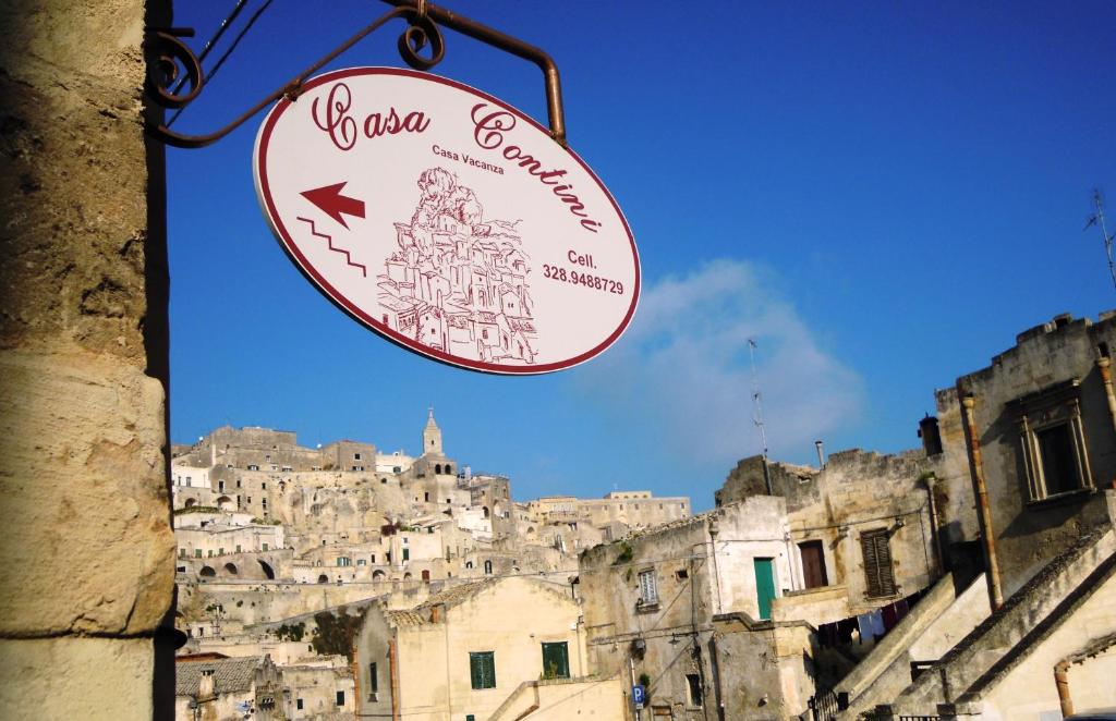 un cartello per un ristorante di fronte a una città di Casa Contini a Matera