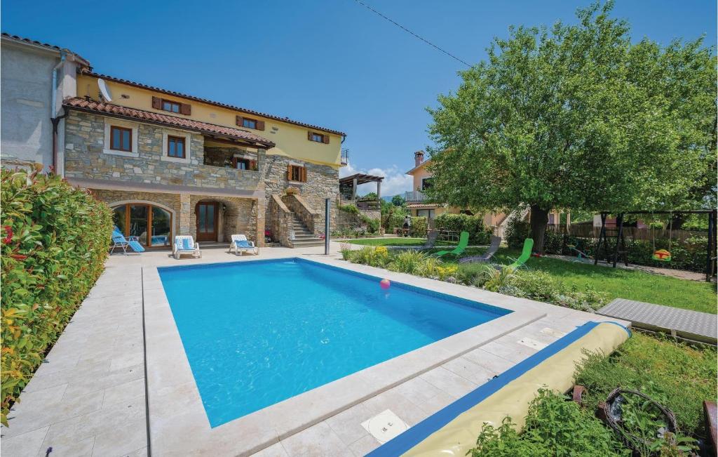 a large swimming pool in front of a house at Stunning Home In Krsan With 4 Bedrooms, Wifi And Outdoor Swimming Pool in Kršan