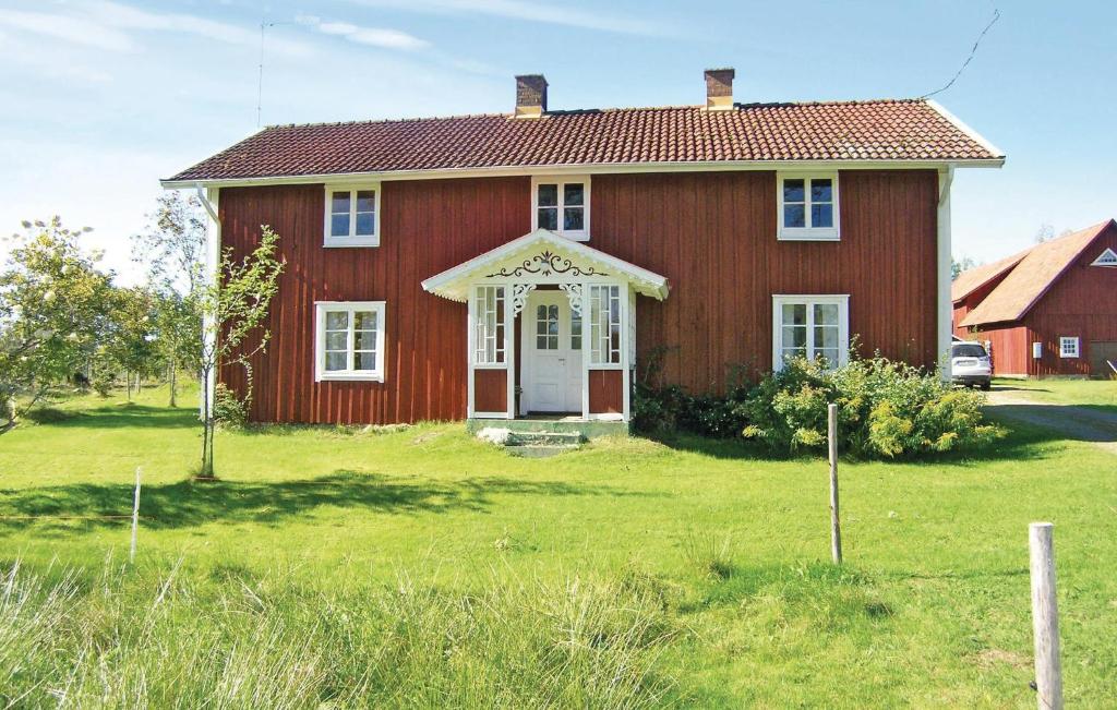 une maison rouge avec une porte blanche dans une cour dans l'établissement 2 Bedroom Cozy Home In Bredaryd, à Sporda