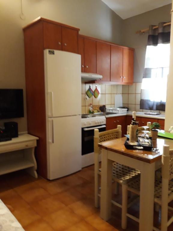 a kitchen with a white refrigerator and a table at Kefallonia Bay Resort in Spartia