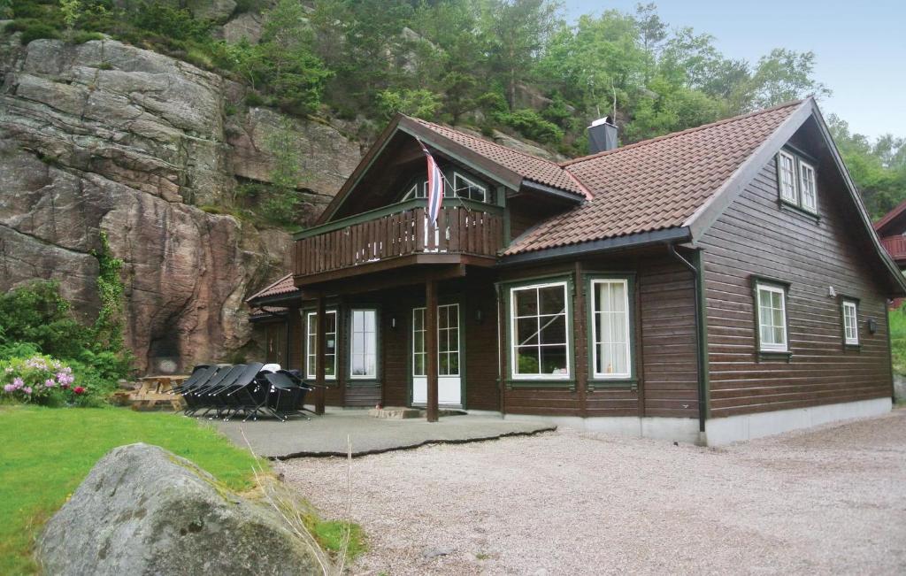 ein Holzhaus mit einem Balkon auf einem Berg in der Unterkunft Gorgeous Home In Lindesnes With House Sea View in Jåsund