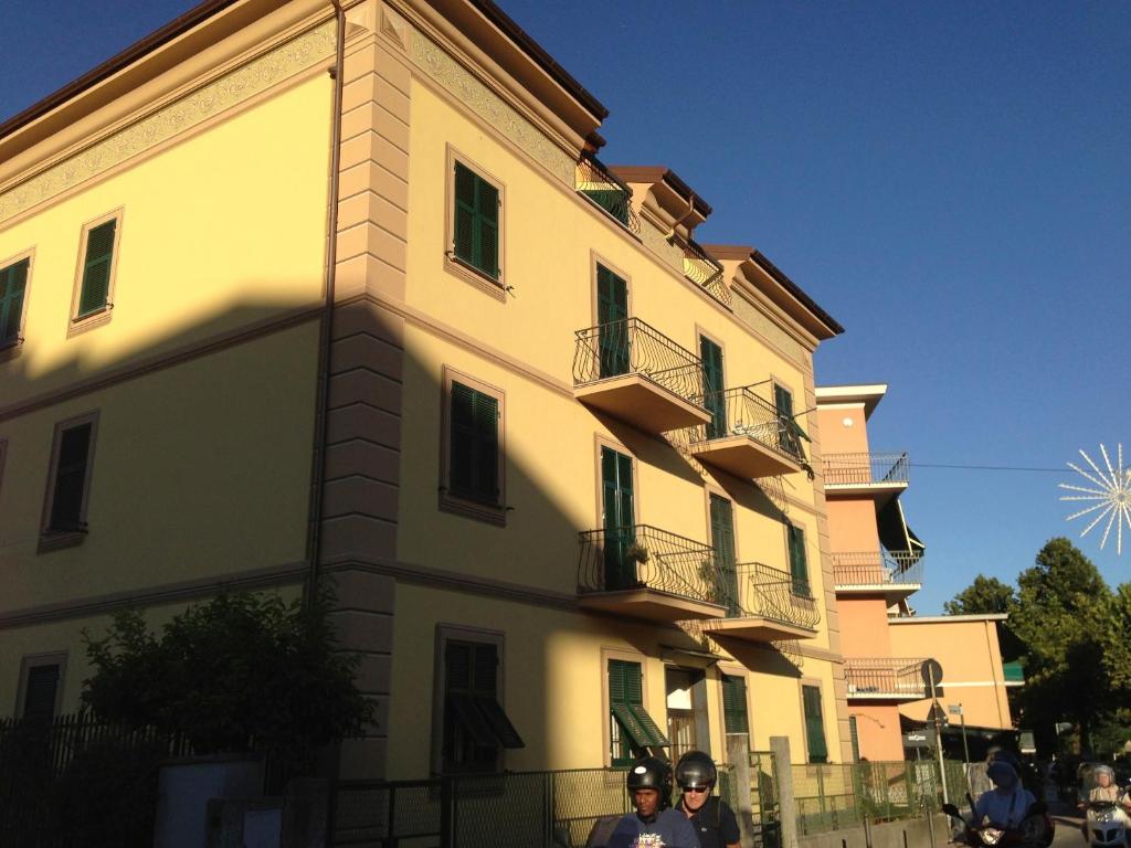 dos personas en motocicleta frente a un edificio en La Casa Di Aaron, en Rapallo