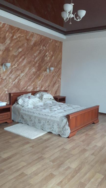 een slaapkamer met een bed en een houten muur bij Киевская 43 in Khorol