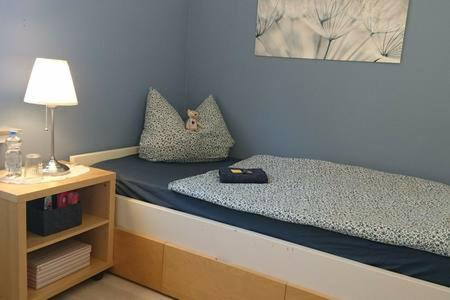 a small bedroom with a bed and a night stand at Bed & Breakfast Bonn in Bonn