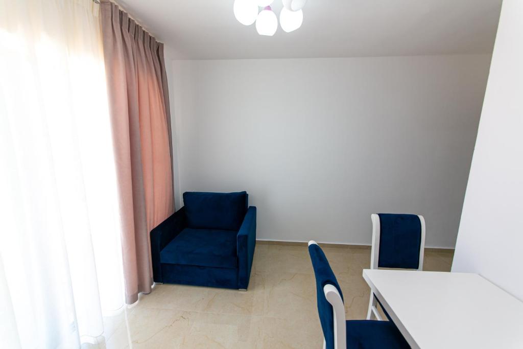 a room with a blue chair and a table at Santa Oliva Suites in Ksamil