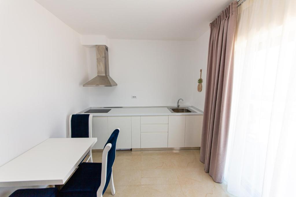a kitchen with a table and a sink and a table and chairs at Santa Oliva Suites in Ksamil