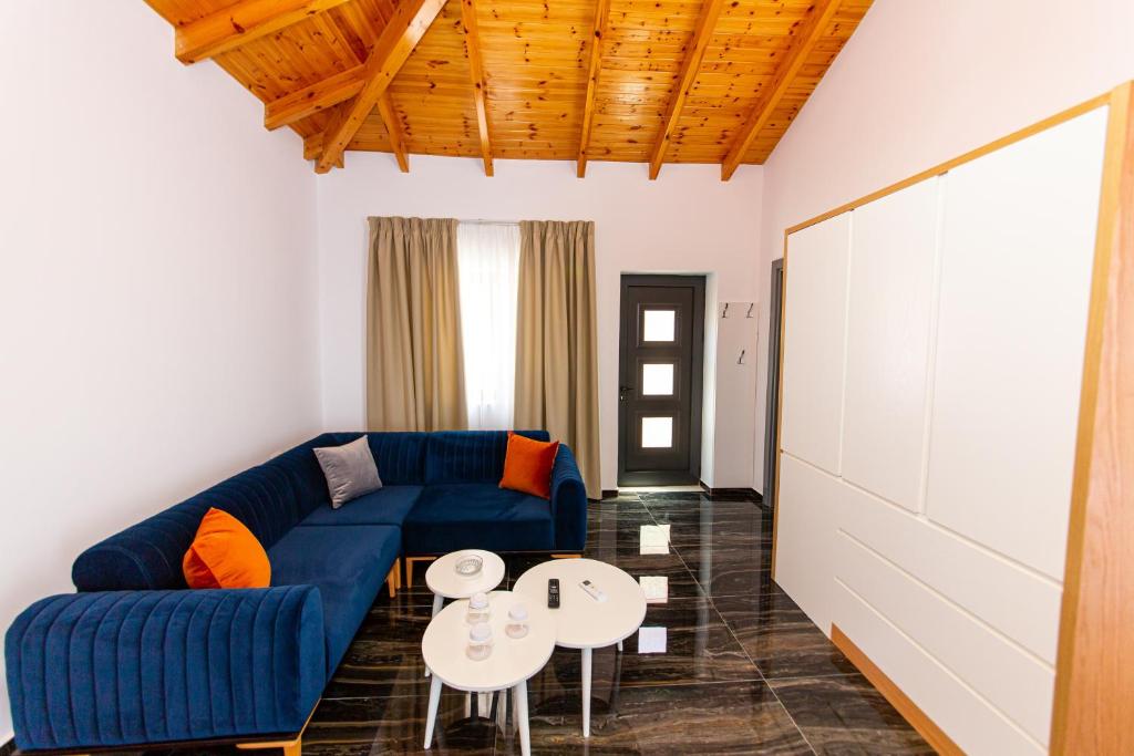 a living room with a blue couch and a table at Santa Oliva Suites in Ksamil