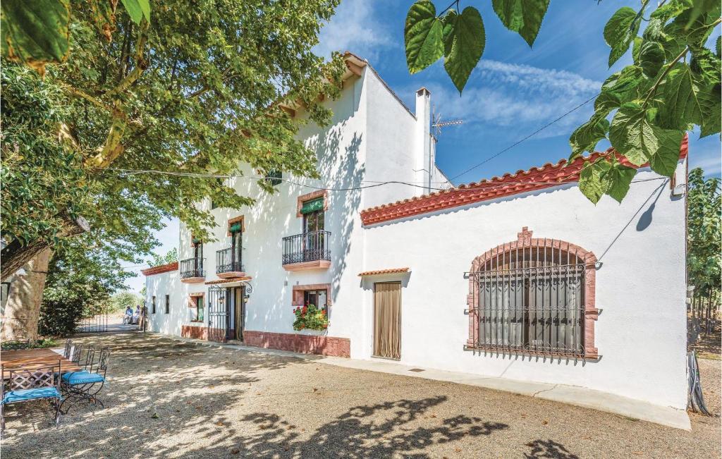 una casa blanca con una puerta en una calle en 6 Bedroom Gorgeous Home In Riudoms, en Riudoms