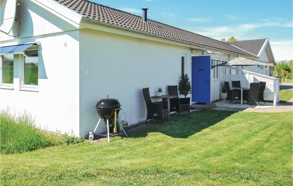 a grill next to a white house with a yard at 2 Bedroom Stunning Home In Borgholm in Borgholm
