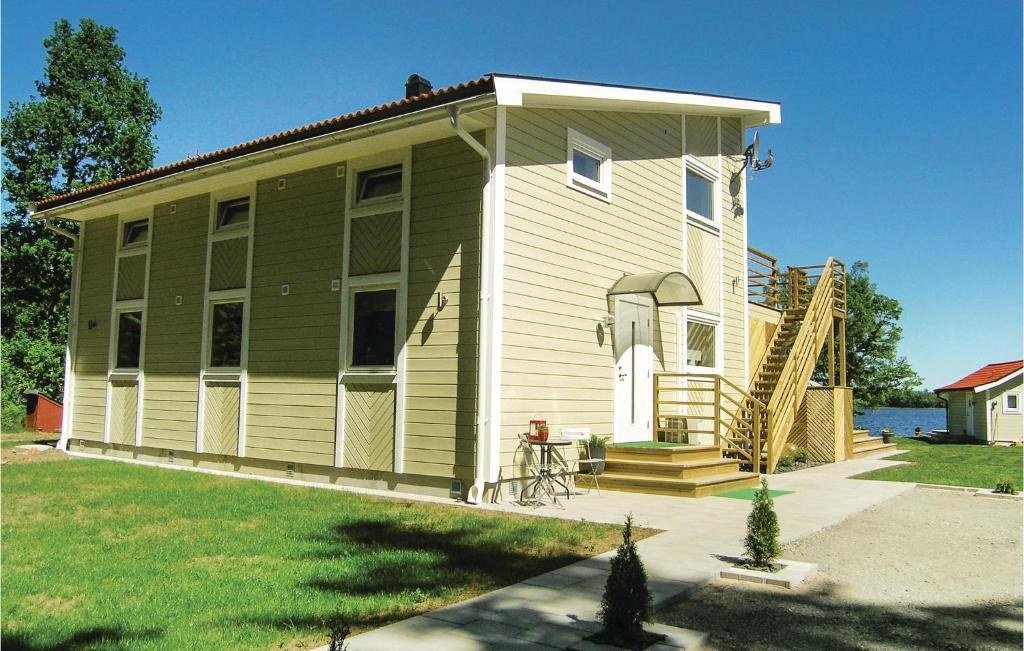 a large green house with a porch and stairs to it at Amazing Home In Bolmsö in Bolmsö