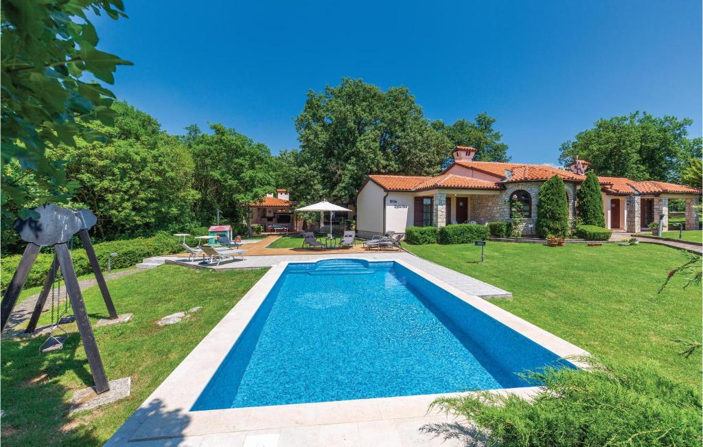 a swimming pool in the yard of a house at Stunning Home In Belavici With 3 Bedrooms, Wifi And Outdoor Swimming Pool in Hreljići
