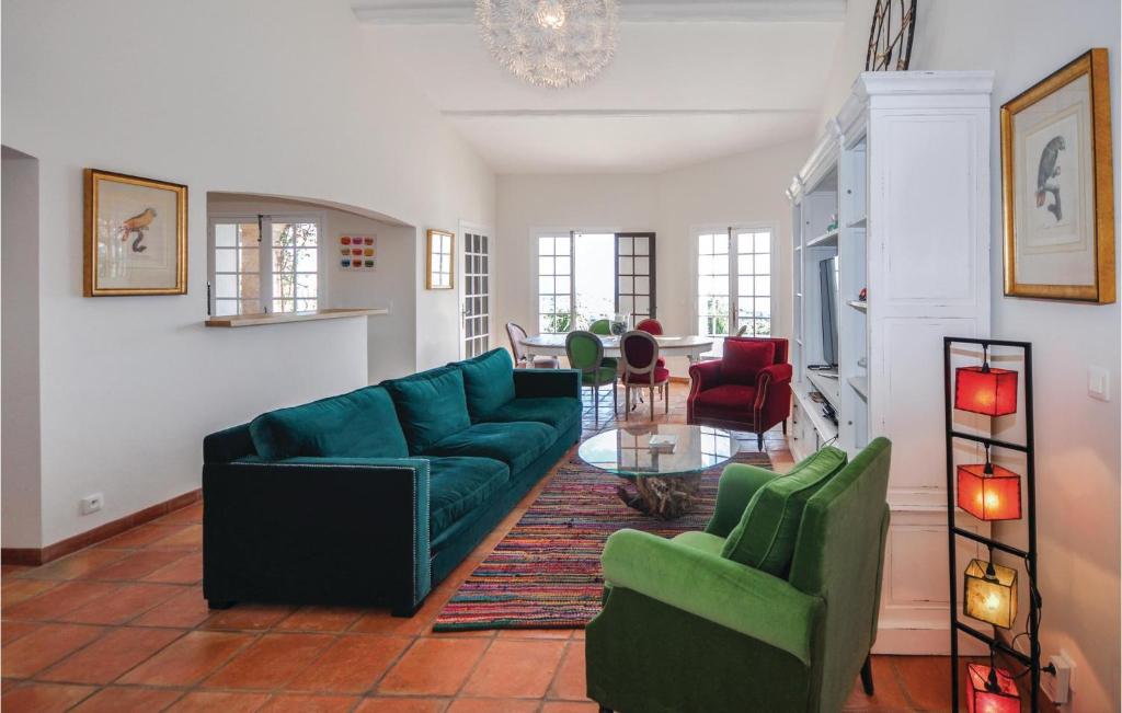 ein Wohnzimmer mit einem blauen Sofa und Stühlen in der Unterkunft Cozy Home In Les Issambres in Les Issambres