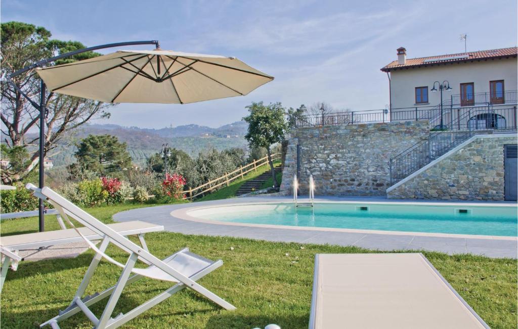 a chair and an umbrella next to a swimming pool at Dependance in Lamporecchio