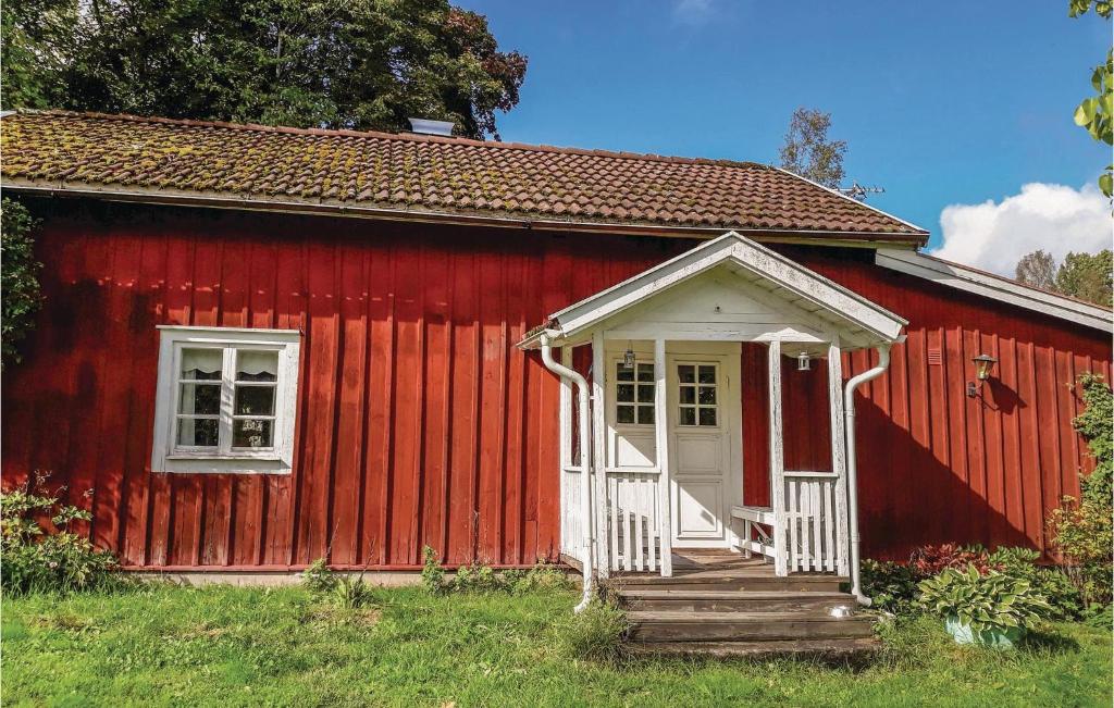 a red house with a white door and stairs in front at 2 Bedroom Cozy Home In Mariannelund in Mariannelund