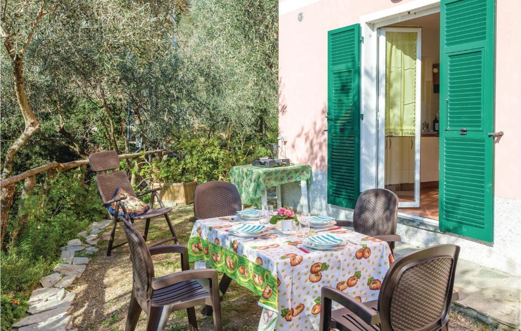 einen Tisch und Stühle auf einer Terrasse mit grünen Rollläden in der Unterkunft Pian Dellaia 1 in Bracco