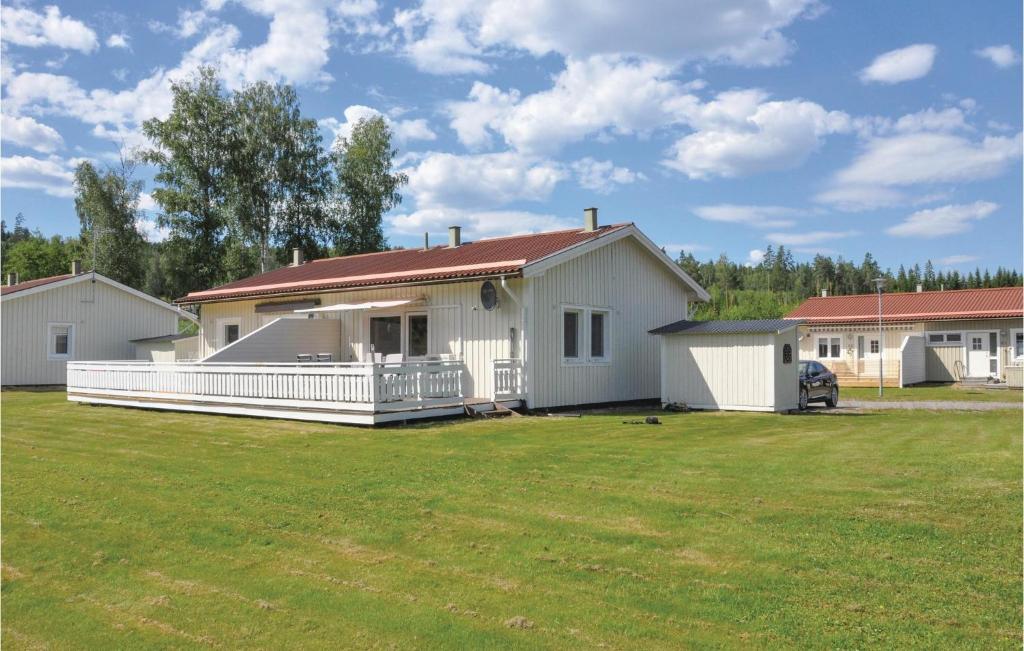 a white house with a large yard in front of it at Cozy Home In motsfors With Kitchen in Gryttved