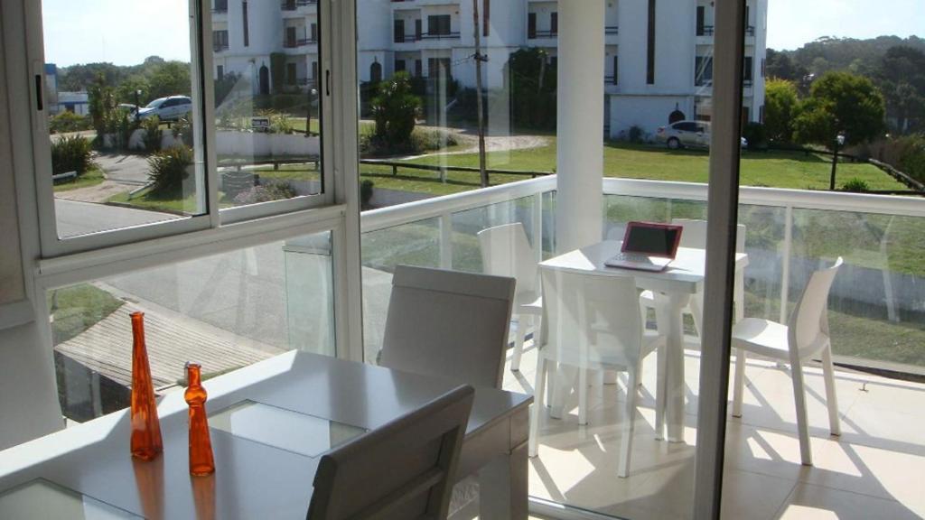 balcón con mesa blanca y sillas blancas en Pinamar Alquilo Depto A 150 Mts Del Mar en Pinamar