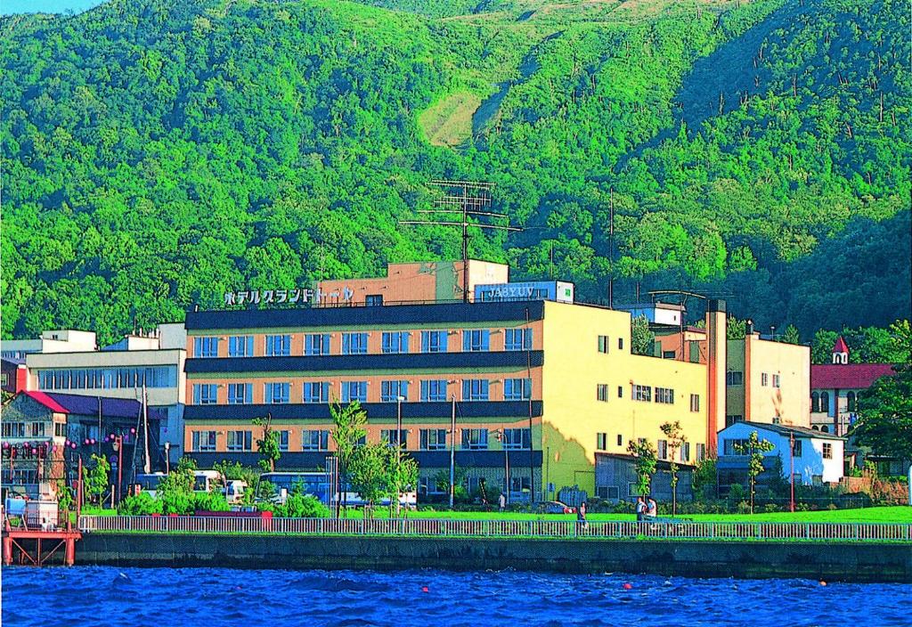 a large building next to a body of water at Hotel Grand Toya in Lake Toya