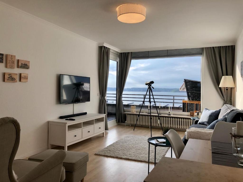 sala de estar con TV y ventana grande en Förde-Loge 20 - Glücksburg, en Glücksburg