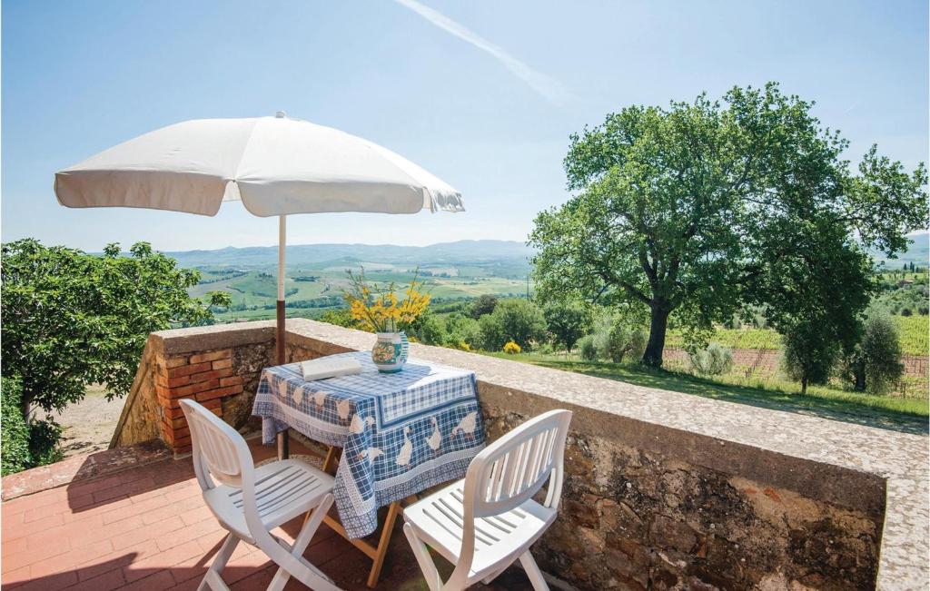 a table and chairs with an umbrella on a patio at Schivanoia 3 in Bagno Vignoni
