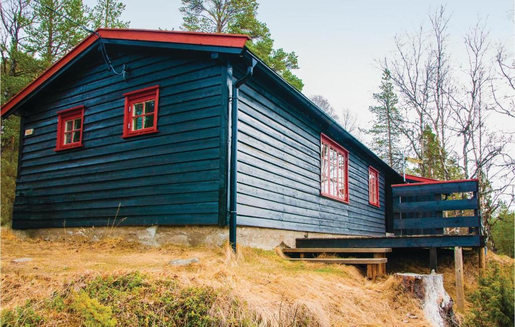 a blue house with red windows on a hill at Bjerkly in Trøan