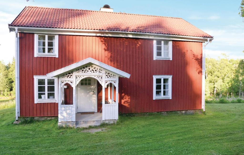 VrigstadにあるNice Home In Vrigstad With 1 Bedrooms And Wifiの草の中に白い扉が付いた赤い家