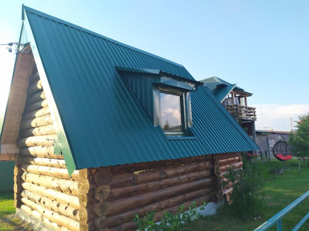 a house with a green roof on top of it at Cottage MANSION in Žabljak