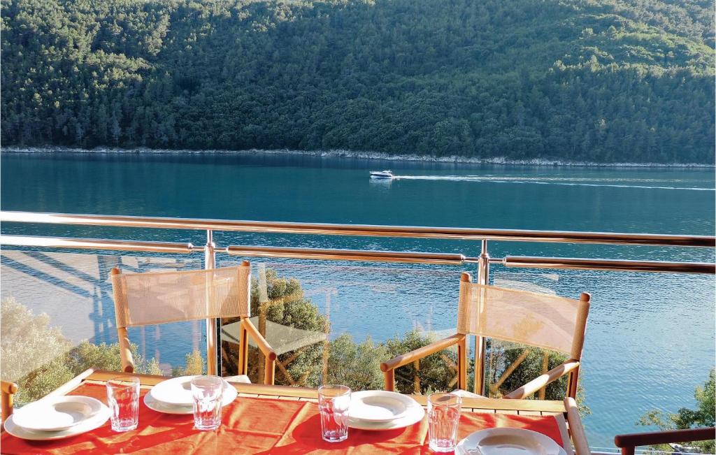 a table with chairs and a view of a lake at Lovely Apartment In Labin With Wifi in Labin