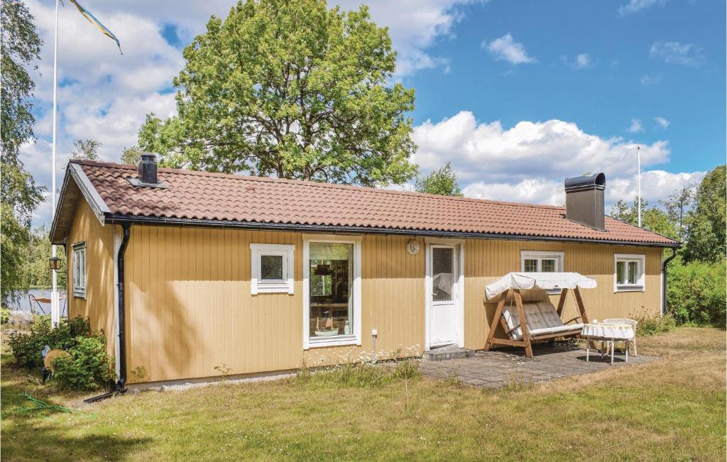 una pequeña casa amarilla con mesa y silla en Beautiful Home In Nssj With Kitchen, en Nässjö